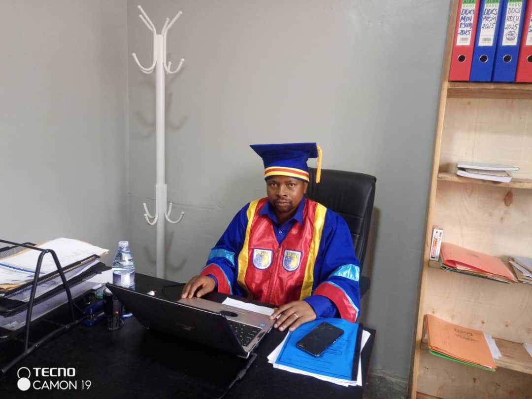 UIAC academic leader in his office wearing official academic attire